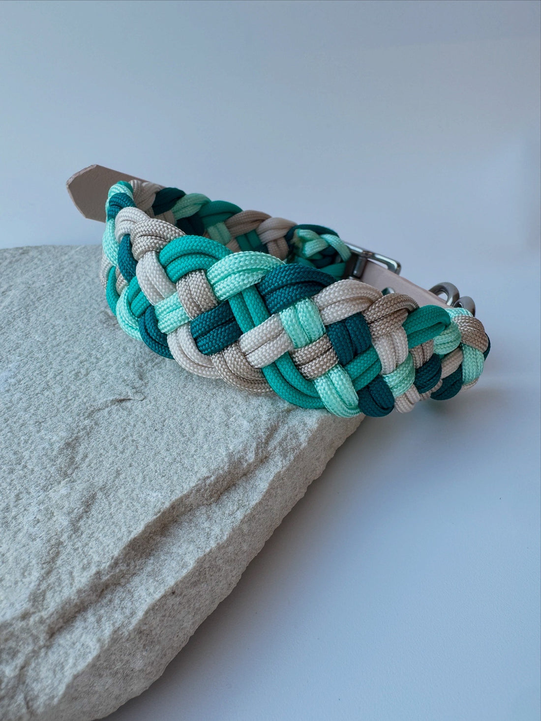 Multicolored braided belt on a textured surface with a light background